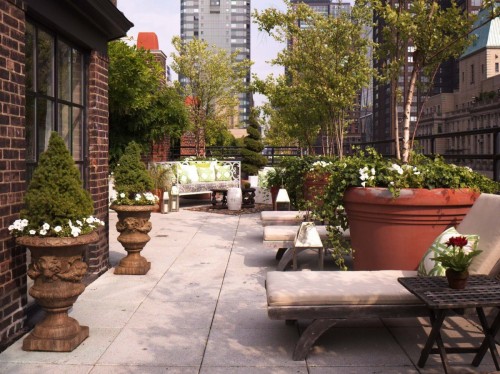 Städtischer Balkon Steinboden Topfpflanzen Kissen Liegen groß verziert