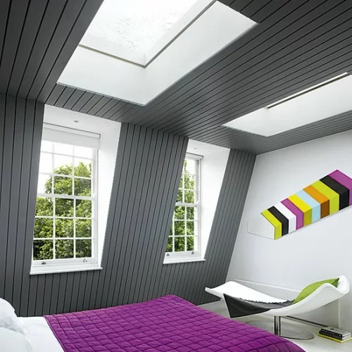 schlafzimmer im dachgeschoss grau wand belag rosa bettdecke dachfenster