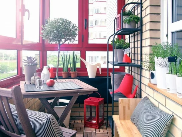 kleiner Balkon Ideen rotes Fensterbrett Möbel Tisch Stühle aus Holz Pflanzen Regal aus Metall für die Topfpflanzen Sitzbank 