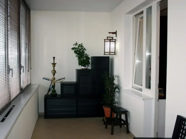 kleiner Balkon Gestaltungsideen weiße Wände schwarze Möbel im optischen Kontrast grüne Topfpflanzen 