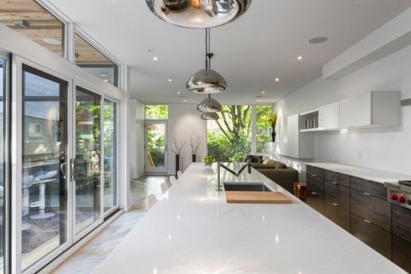 minimalistische residenz ovale metalglänzende pendellampen über weißer kücheninsel