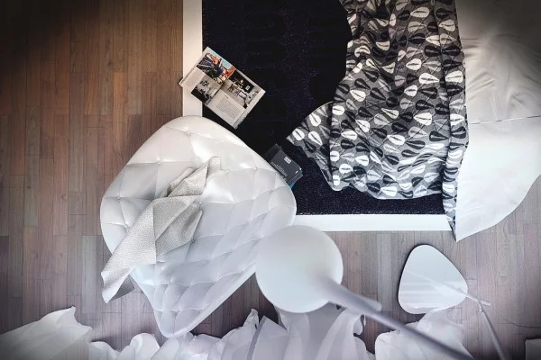 moderne designer schlafzimmer weißer sessel gepolstert und gemusterte steppdecke