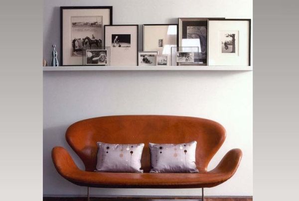 schwarz weiß bilder gestapelt über designer sofa in dunkel orange