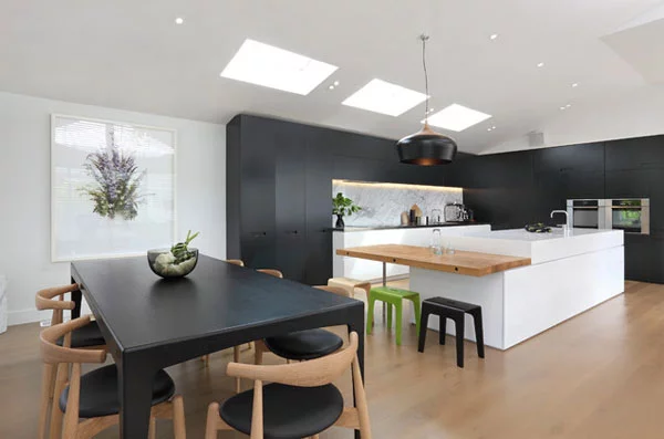 schwarze küchenmöbel und ausgefallene details helles holz viel licht licht duch dachfenster