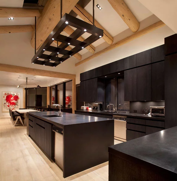 schwarze küchenmöbel und ausgefallene details hohe decke mit massiven holzbalken