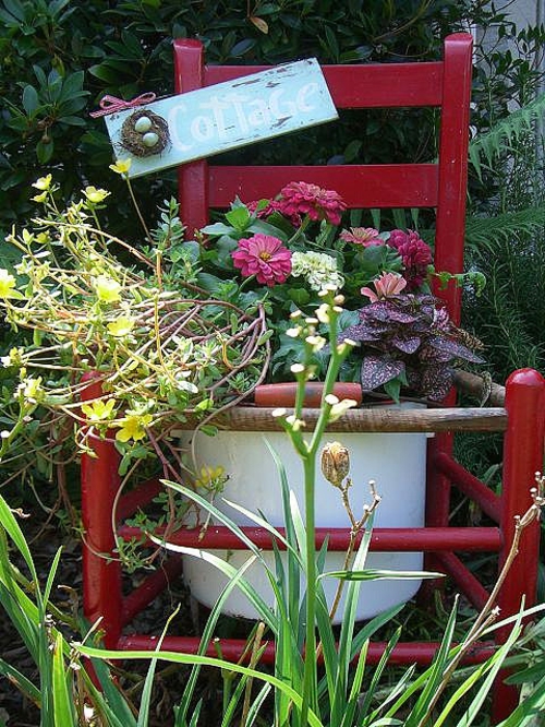 Alte Stühle im Garten mit neuer Funktion rot attraktive Pflanzgefäße