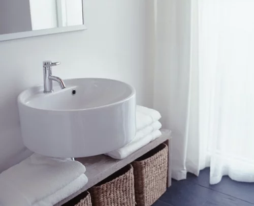 weiße Farbe im Badezimmer waschbecken rund strohkorb tücher