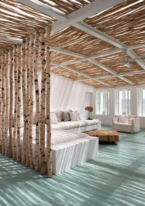 wohnzimmer mit strand birken stämme und strahlend weiße sitzmöbel