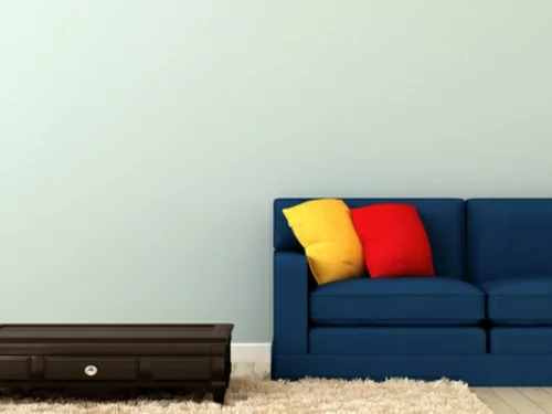 blaues sofa mit bunten kissen und kaffeetisch dekoelemente