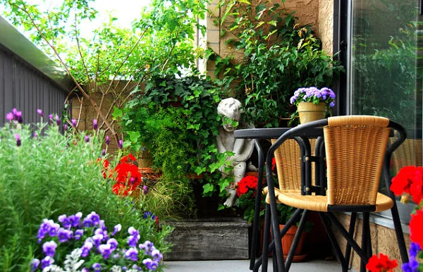 terrassengestaltung mit pflanzen rattan stühle und gips statue