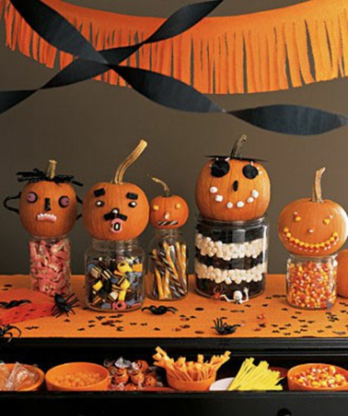 halloween tischdeko gläser mit süßigkeiten und minikürbisse mit gesichtern