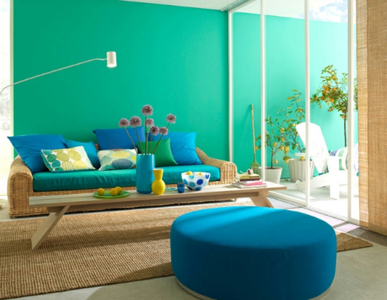 raumgestaltung mit farben blau grün sofa dekokissen hocker licht