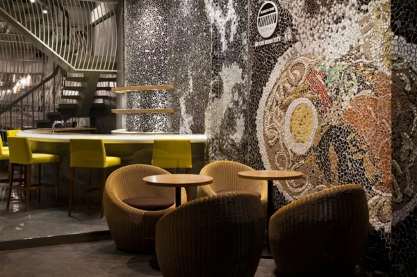 Wandgestaltung mit Mosaikfliesen im Nudel Restaurant rattan sessel
