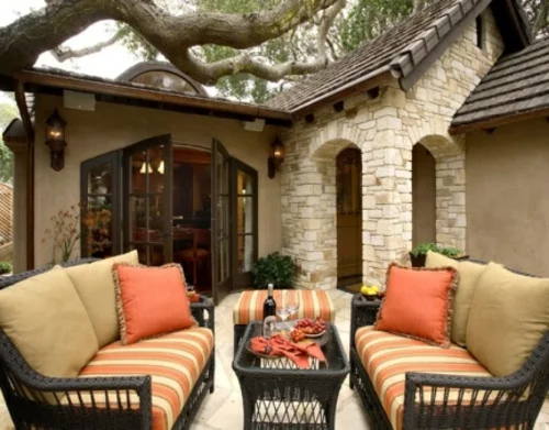 veranda mit Naturstein gestalten orange dekokissen