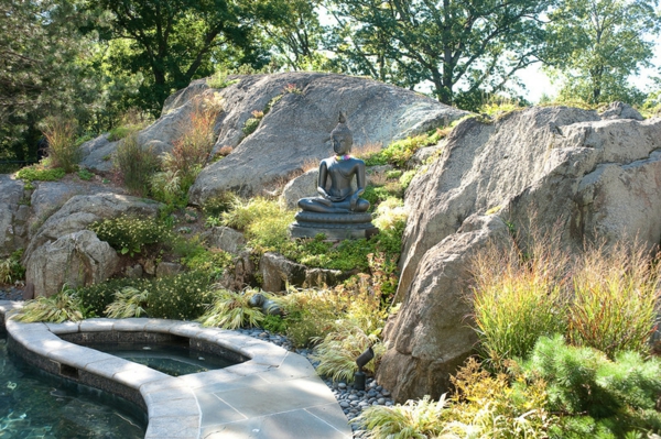 Buddha Figuren im Garten grün laub steine felsen