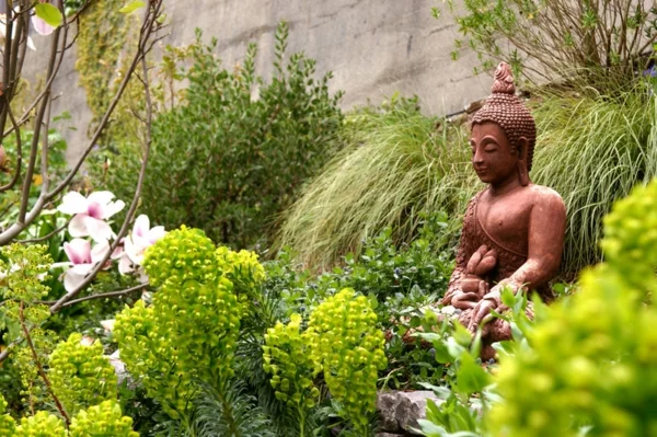 Buddha Figuren im Garten grüne umgebung frisch pflanzen