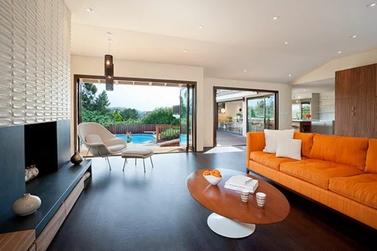wohnzimmer einrichten glastüren pool moderner kamin sofa in orange