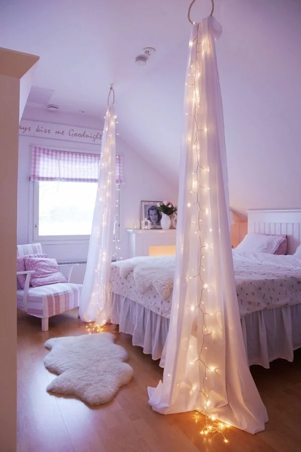 romantisch gestaltetes Schlafzimmer mit Himmelbett und leuchtenden Gardinen 