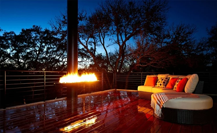grüne architektur terrasse holzboden lounge möbel kamin nachtsüber