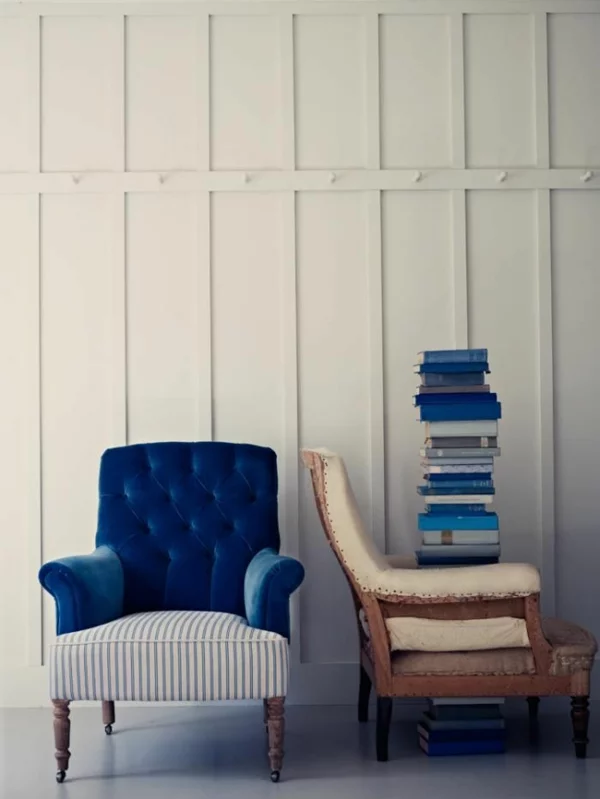 Kunststoffpaneele streichen ganz in Weiß Polstersessel in zwei Farben Stapel Bücher auf einem alten Möbelstück