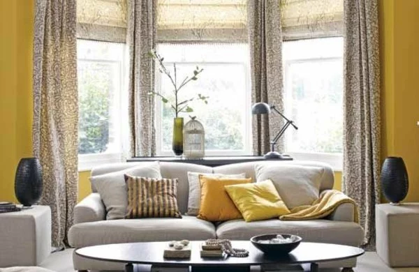 Gelbe und graue Gardinen hinter dem Sofa 