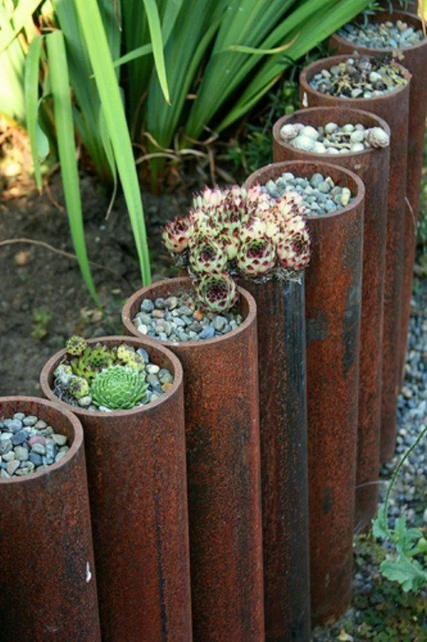 Gartenzaungestaltung Idee aus alten Röhren bepflanzt mit Sukkulenten