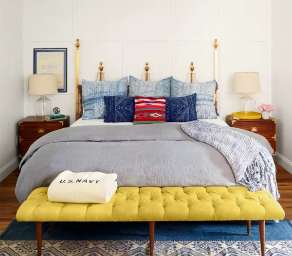schlafzimmer gestalten metallbett kopfteil bunte dekokissen bettbank gelb retro nachtkonsolen tischleuchten