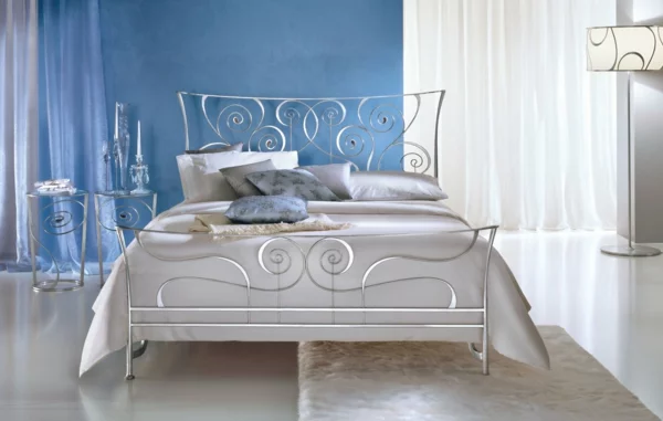 schlafzimmer gestalten metallbett rankenmuster edelstahl geschwungene formen wandfarbe blau