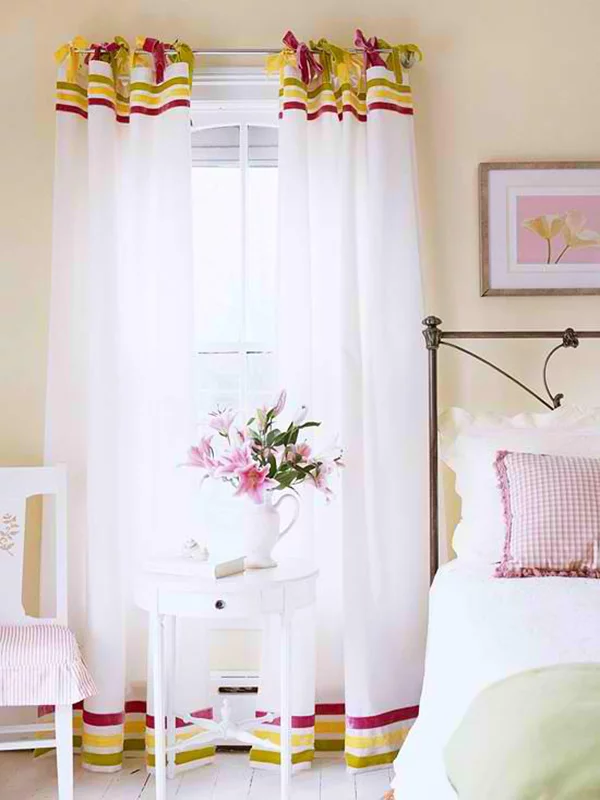 im Schlafzimmer schöne leichte Vorhänge aus durchsichtigem Stoff mit bunten Kanten oben und unten 