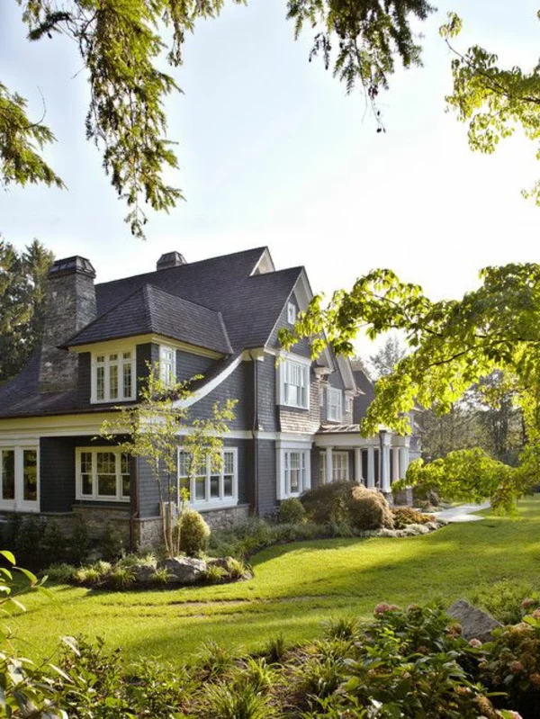 weiße Fensterrahmen, graue Fassade und schön geordneter Garten