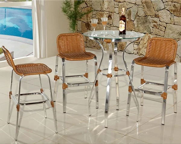 Couchtisch rund aus Glas und Metall mit drei Stühlen zum Kaffee oder Bier trinken Steinwand im Hintergrund Pool 