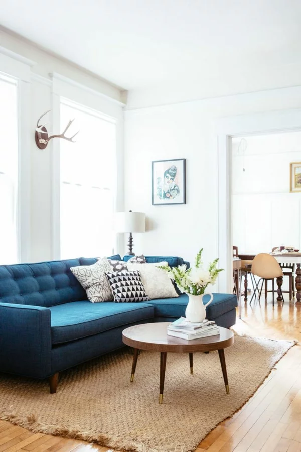 klassisches Design im Wohnzimmer blaues Sofa Couchtisch rund aus Holz 