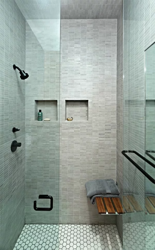 kleines Badezimmer einrichten bodengleiche Dusche graue Fliesen Glaswand Sitzbank aus Holz 