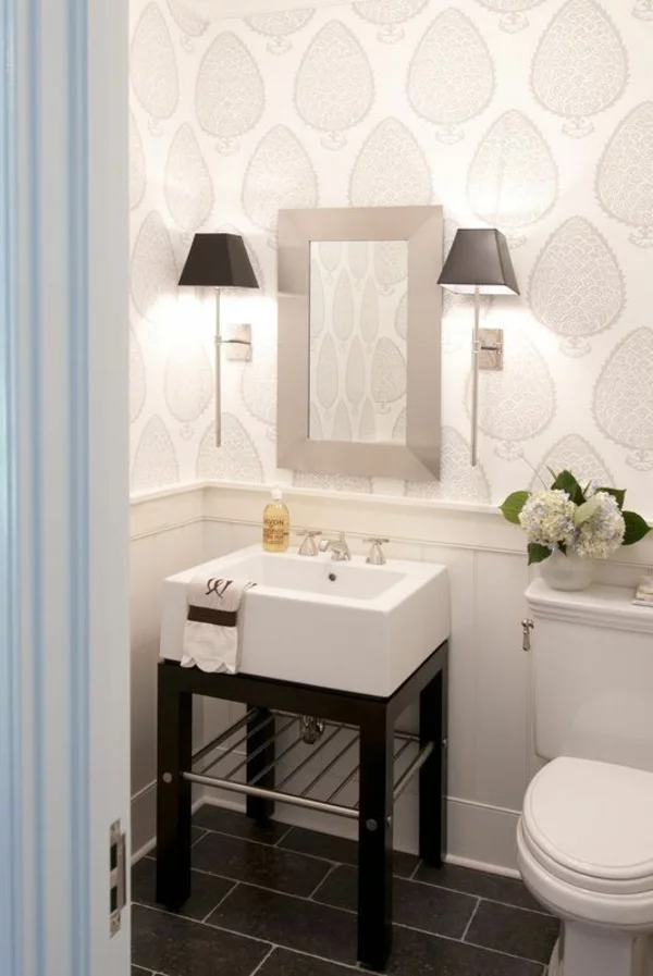 kleines Bad einrichten Waschbecken Wandtapeten Wandlampen Vase mit weißen Blumen Kontrast weiß schwarz schwarze Bodenfliesen 