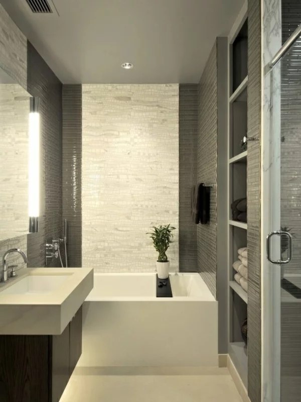 schick gestaltetes Badezimmer helle Fliesen eingebaute Beleuchtung offenes Badregal für Handtücher