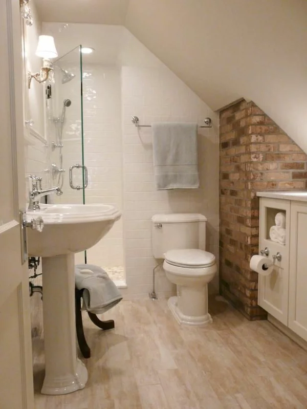 kleines Badezimmer Fliesen in Holzoptik Ziegelwand als Akzent WC unter Dachschräge helle Badgestaltung