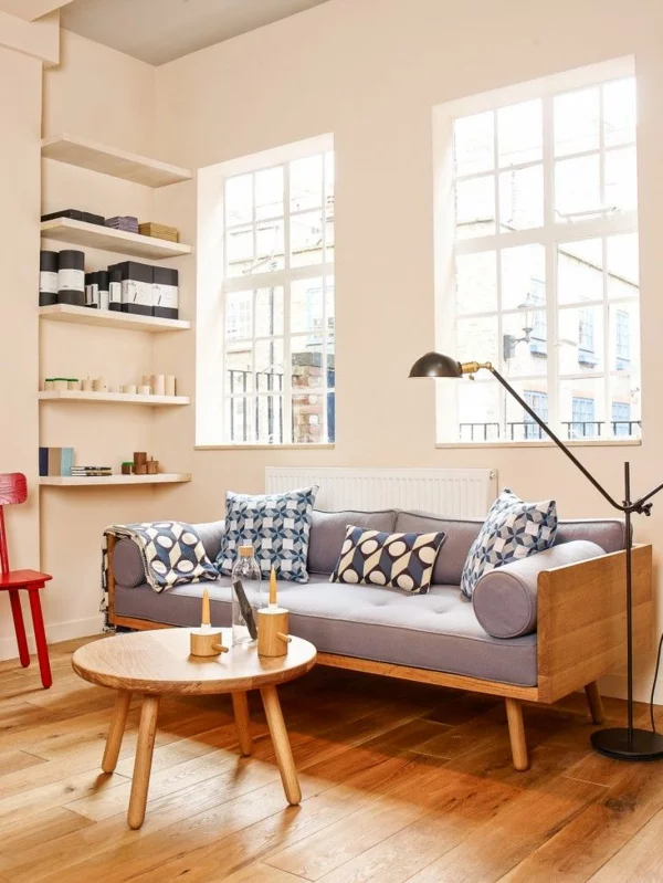einfache Einrichtung im Wohnzimmer tolle Ideen Holzboden Polstersofa runder Holztisch 