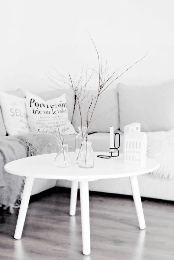 moderne Wohnzimmergestaltung ganz in Weiß runder Couchtisch aus Holz schöne Tischdeko 
