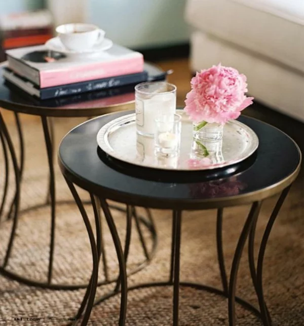zwei runde Couchtische im Wohnzimmer Tischdeko Blumen Bücher und Kerzen 