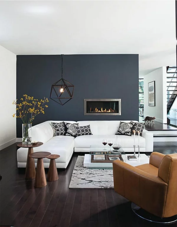 Wandfarben dunkelblau und grau im Wohnzimmer weißes Sofa kleine Holztische daneben