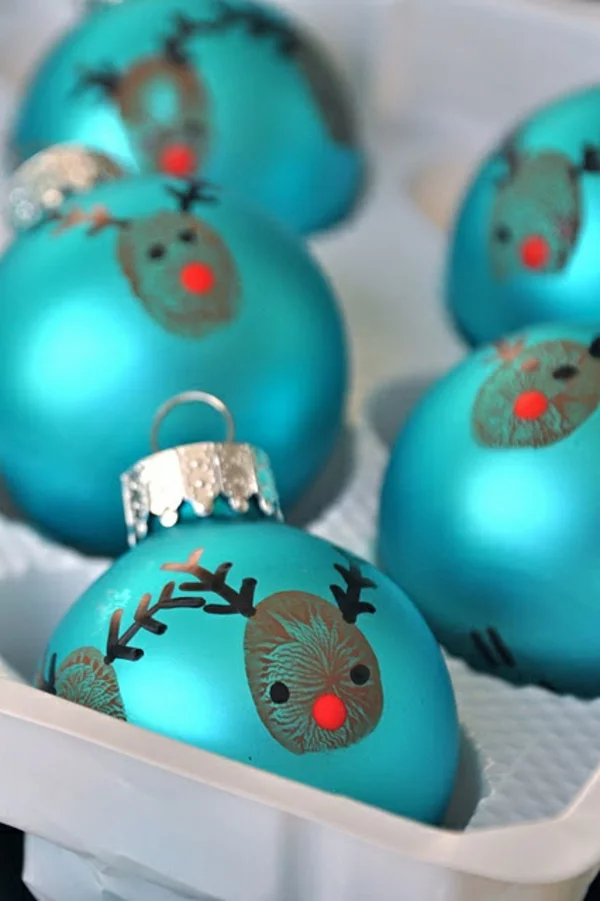 Bastelideen für Weihnachten blaue Weihnachtskuugeln dekorieren mit Hirschgesichtern und Fingerabdrücken