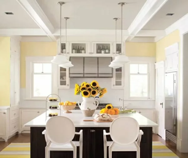 Wwandfarbe pastellgelb in der stilvoll eingerichteten Küche mit frhlichen Gelbakzenten durch Sonnenblumen 