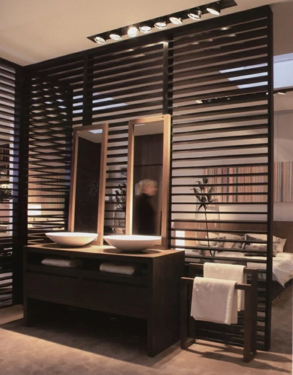 eleganter Raumtrenner aus dunklem Holz Trennwand zwischen Bad und Schlafzimmer