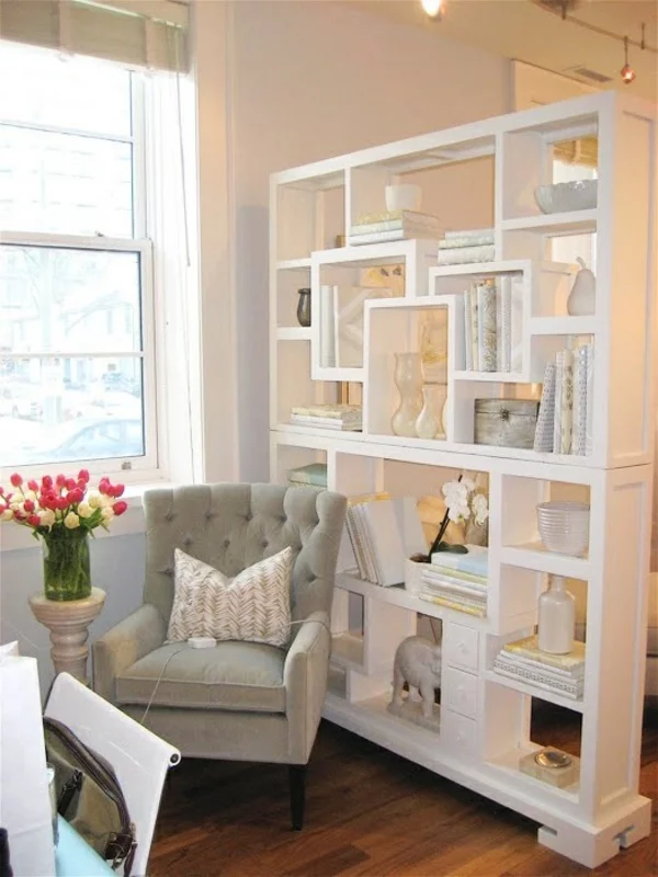gemütliche Leseecke durch Bücherregal aus weißem Holz vom offenen Wohnbereich abtrennen
