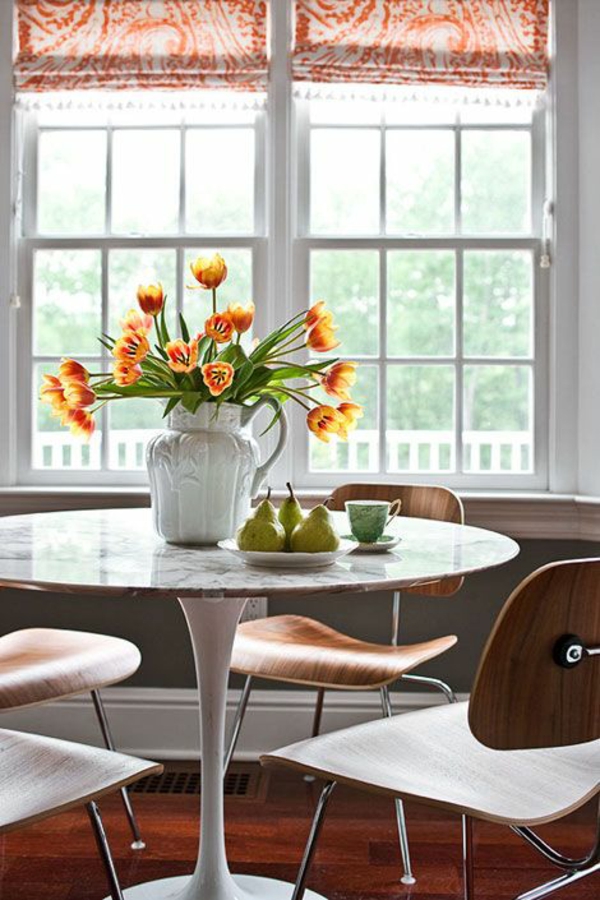 runder esszimmertisch mit stühlen vase mit tulpen