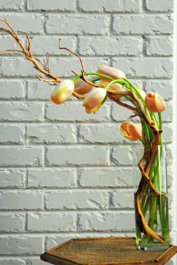 tischdeko mit tulpen blumen arrangieren couchtisch holz ziegelwand