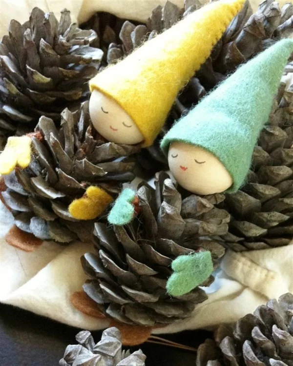 Weihnachtsbasteln mit Kindern DIY Ideen kleine Männchen aus Tannenzapfen mit Hüten aus Filz 