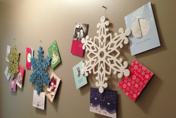 einfache Ideen für Weihnachtskarten basteln Wanddekoration mit Karten und Schneeflocken aus Styropor