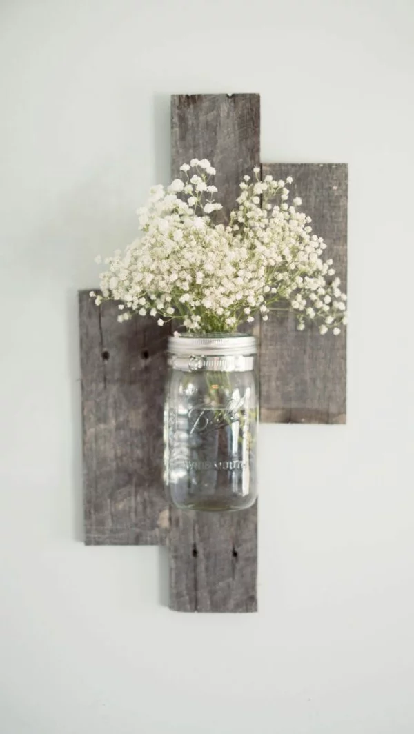 Wanddeko aus Holz selber machen einfaches DIY Projekt im rustikalen Stil mit Holzpaletten und Vase mit Blumen 