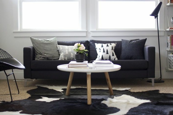 fell teppich wohnzimmer ovaler couchtisch schwarzes sofa